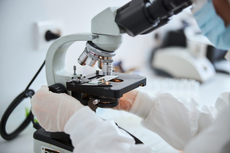 lab-technician-examining-cells-under-the-microscop